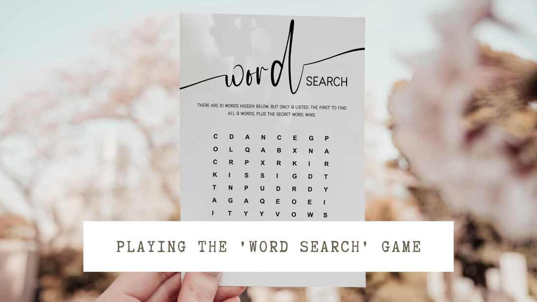 Image of a hand holding a word search game card up in front of pink blossoms. Text overlay: Playing the 'word search' game