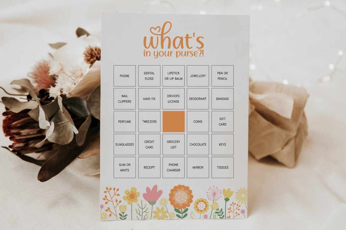 Spring themed 'what's in your purse' bingo game cards leaning against dried flower bunch