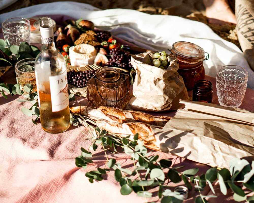 Picnic Food Ideas such as grapes, jams, wine, cheese, crackers and fruits