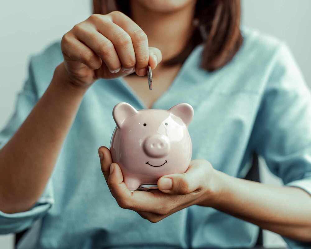 Kitchen Tea Budget - image of a woman putting a coin into a piggy bank