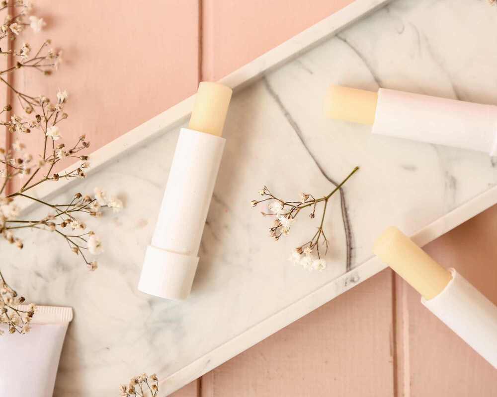 Sticks of natural lip balm on a marble tray. 